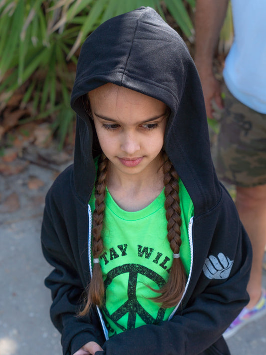 Young girl wearing a black hoodie with a green shirt underneath