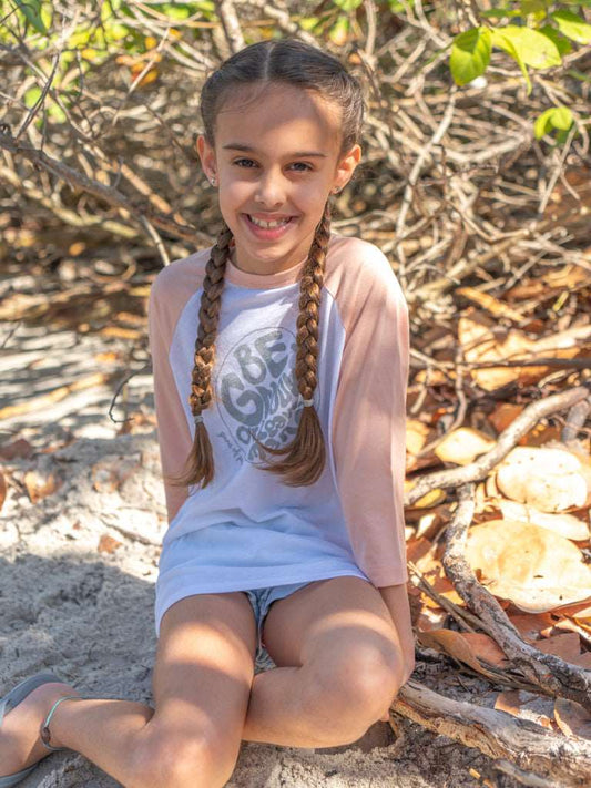 Young girl wearing a 'Be Groovy' shirt on the beach