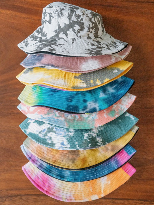 Stack of colorful bucket hats on a wooden surface