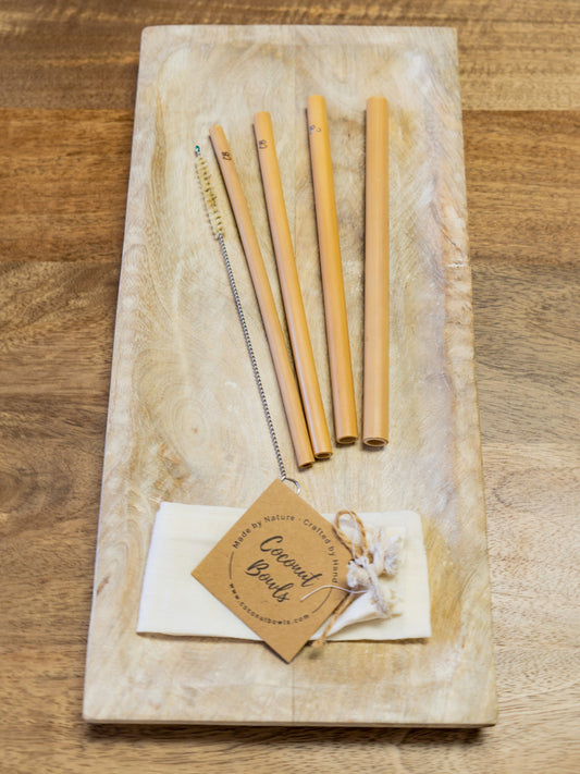 Set of bamboo straws on a wooden board with a tag indicating brand.