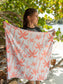 Person holding a pink palm tree patterned towel outdoors