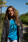 Girl wearing dark gray zip up hoodie with a blue shirt underneath