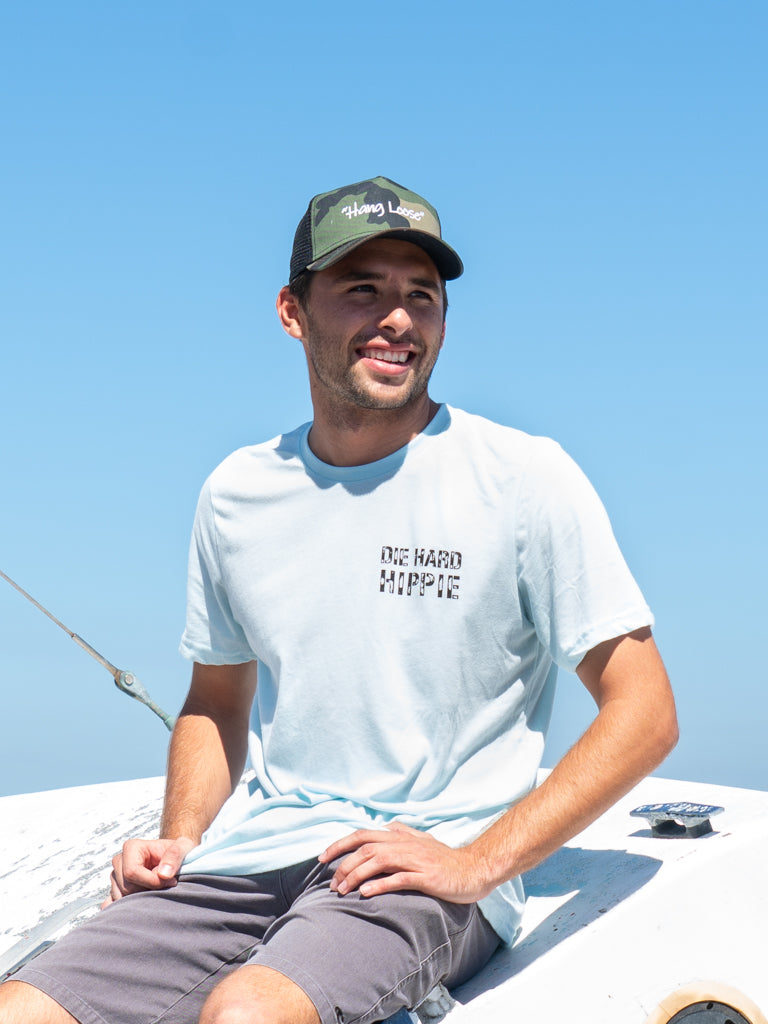 A person wearing a black trucker hat with a logo on the front.