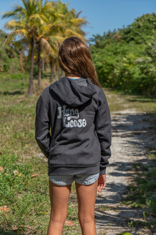 Girl wearing gray hoodie with the words 'Hang Loose' on the back