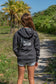 Girl wearing gray hoodie with the words 'Hang Loose' on the back