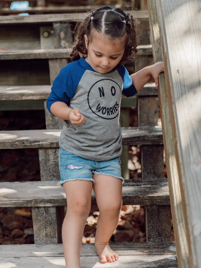 Child standing on a wooden boardwalk by the ocean