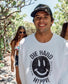 Man wearing a white sweatshirt with a smiley face design, standing in water.