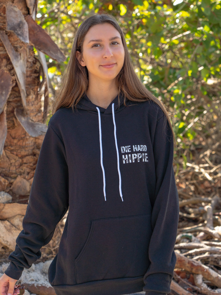 Woman wearing a black hoodie with 'Die Hard Hippie' text, standing outdoors.