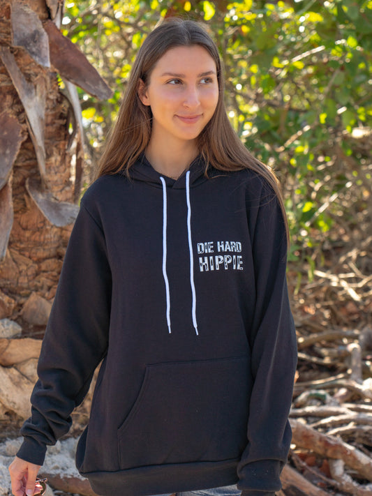 Woman wearing a black hoodie with 'Die Hard Hippie' text, standing outdoors.