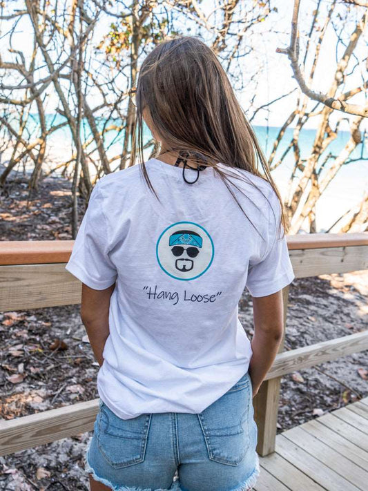 Man wearing a white t-shirt with 'Hang Loose' logo on the beach