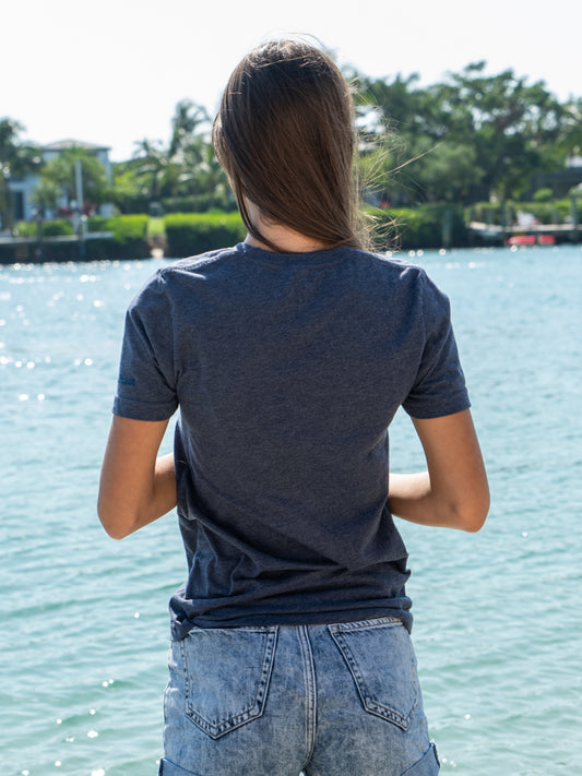 Woman wearing a blue t-shirt by a body of water