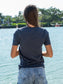 Woman wearing a blue t-shirt by a body of water