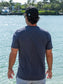 Man wearing a blue t-shirt by a body of water