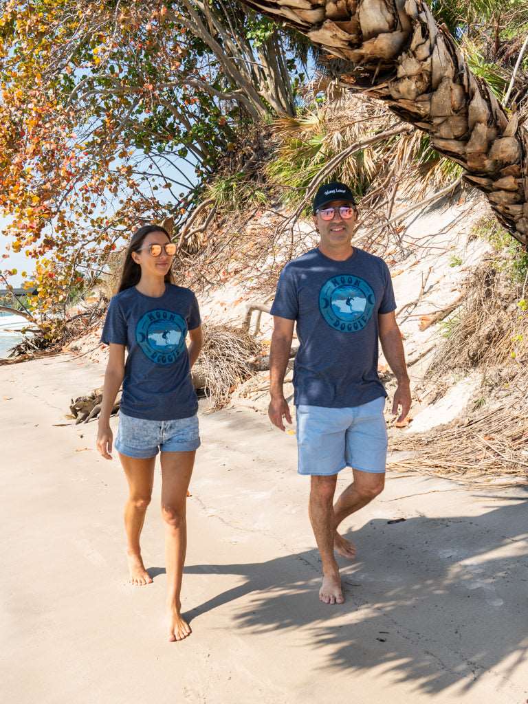 Man and woman walking wearing matching blue t-shirts with a design