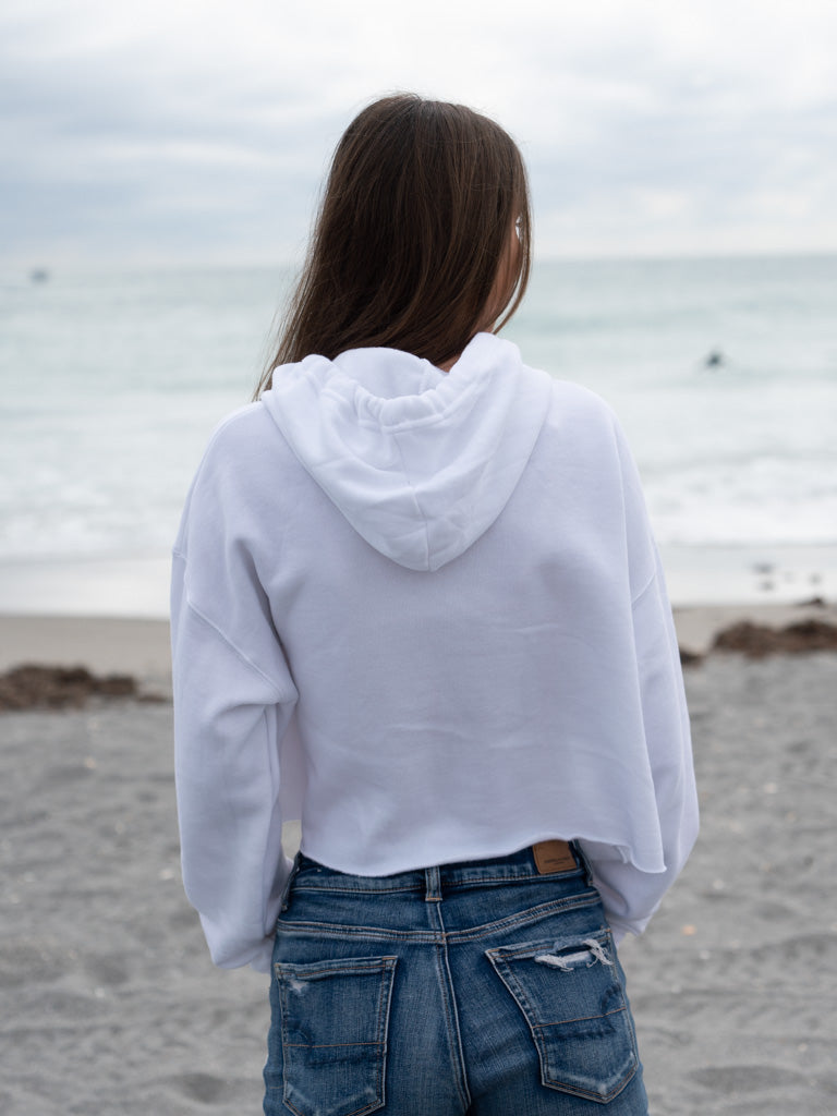 Woman wearing a white hoodie on a beach