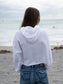 Woman wearing a white hoodie on a beach