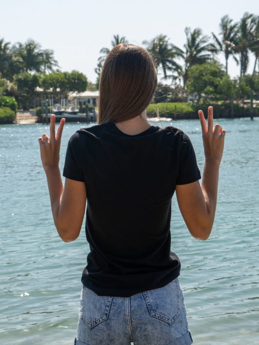 Person wearing a black t-shirt by the water