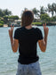 Person wearing a black t-shirt by the water