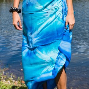Person wearing a blue dress standing by a body of water