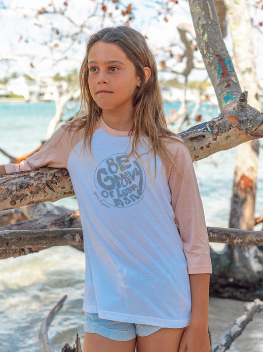 Young girl wearing a 'Be Groovy' shirt by the ocean
