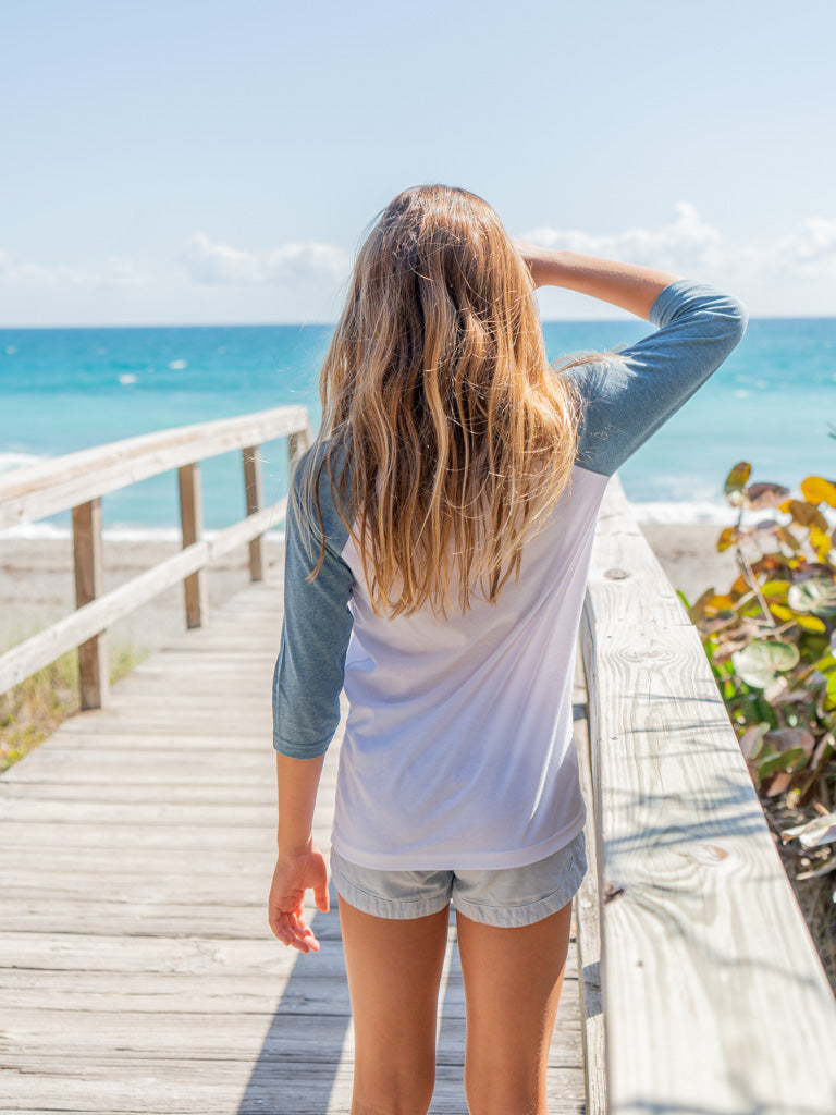 Young girl wearing a 'Be Groovy' looking out at the ocean
