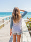Young girl wearing a 'Be Groovy' looking out at the ocean