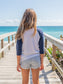 Young girl wearing a 'Be Groovy' shirt by the ocean