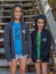 Two children wearing gray hoodies with visible branding on a wooden staircase.