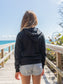 Young girl wearing black hoodie on a beach