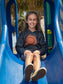 Young girl wearing black hoodies with a sun design, sitting on a slide