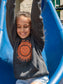 Young girl wearing grey hoodies with a sun design, sliding down a slide