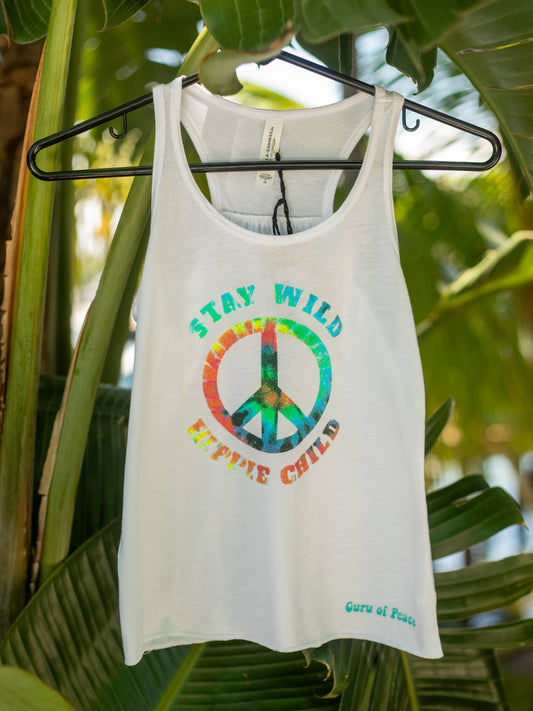 White tank top with colorful peace sign and text 'Stay Wild, Explore Child' on a hanger against a leafy green background.